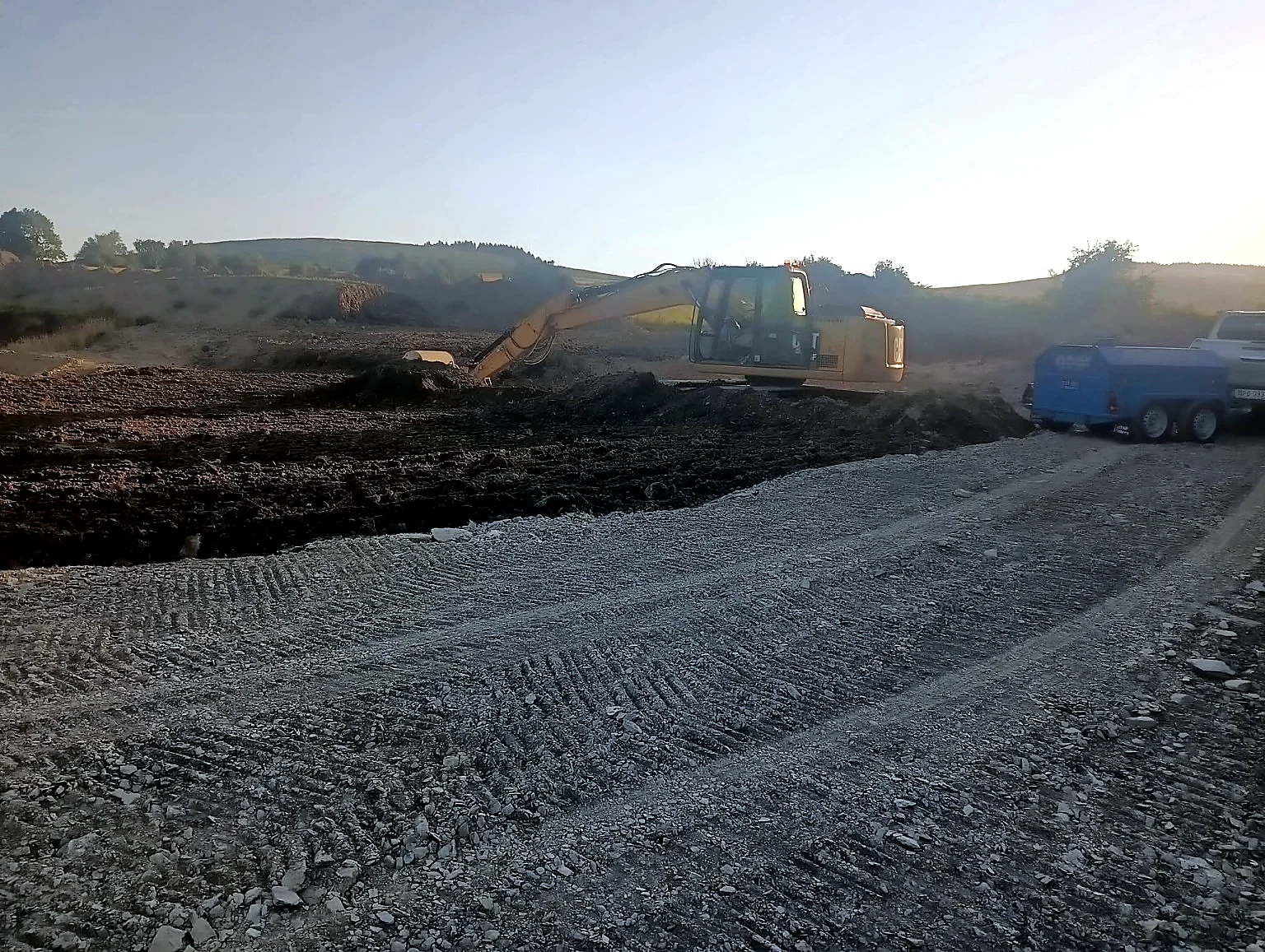 Excavator carrying out earthmoving works at sunset